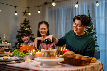 Asian lovely family celebrating Christmas party together in house.