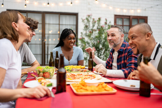 Multi-ethnic family having fun, enjoy party outdoors in the garden. 