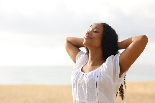 Black woman resting breathing on the beach
