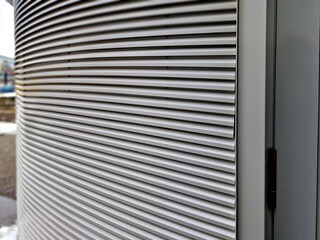 building is lined with square panels. metal sheet wall cladding with scalloped design. corrugated...