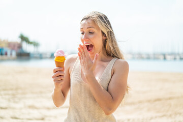 Young blonde woman with a cornet ice cream at outdoors with surprise and shocked facial expression
