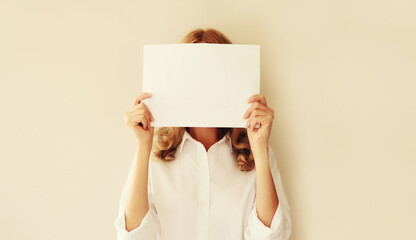 Woman showing and holding white blank sheet of paper document for advertising text blank copy space on studio background