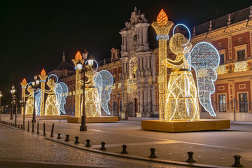 Christmas lights decoration in the shape of an angel holding a torch in from of The Palace of San...
