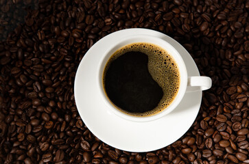 Fresh black coffee cup of hot coffee with coffee beans on dark background