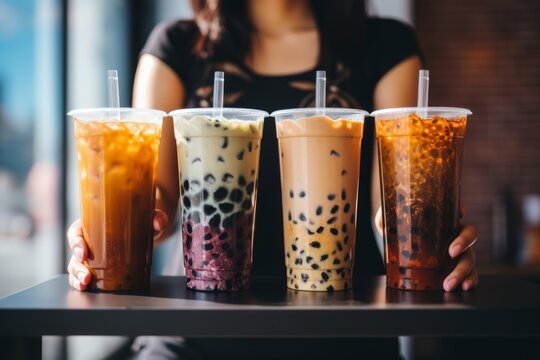 four plastic glasses of korean bubble tea prepared in modern cafe, standing in row on bar stand, trendy beverage.