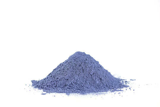 Heap of dry blue matcha powder from clitoria flowers on a white background.