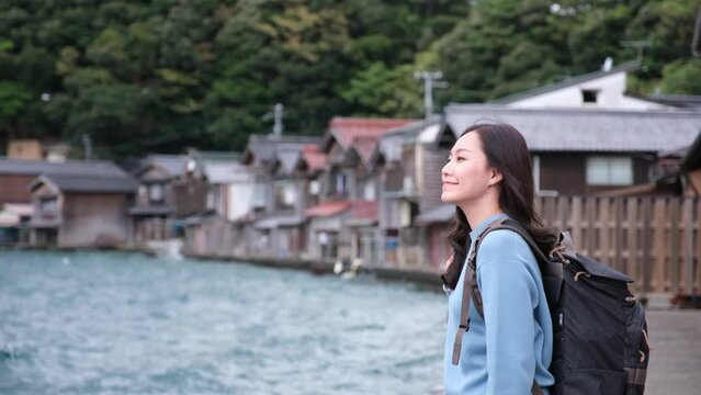 A female tourist standing by the ocean in Ine village, Japan
