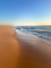 Sandy ocean shoreline, empty beach, warm evening light