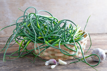 Garlic arrows. A bunch of greens on the table. Vegetable healthy vitamin food. Green stem stalks...
