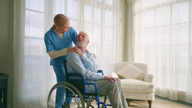 Doctor hold caring hands on shoulder of sad elderly patient.Physician help support disabled retired man patient.Nurse supports the sick man and puts hand on shoulder is grateful.Caring and empathy