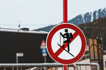 A no ski climbing sign prominently displayed against a backdrop of distant mountains and a metal...