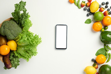 Flatlay with smartphone and various fruits and vegetables