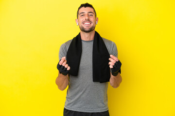 Young sport caucasian man isolated on yellow background making money gesture