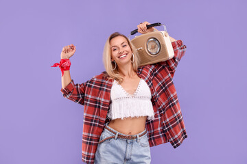 Happy hippie woman with retro radio receiver on purple background