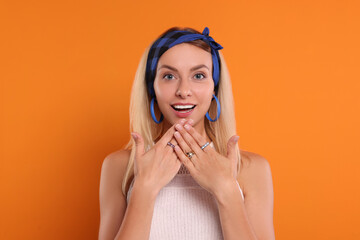 Portrait of surprised hippie woman on orange background