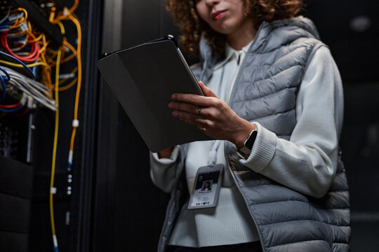 IT professional using tablet PC and setting supercomputer system in database room
