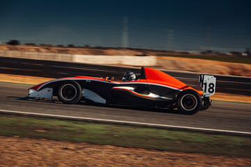 Formula car go fast at the raceway during sunset - obrazy, fototapety, plakaty