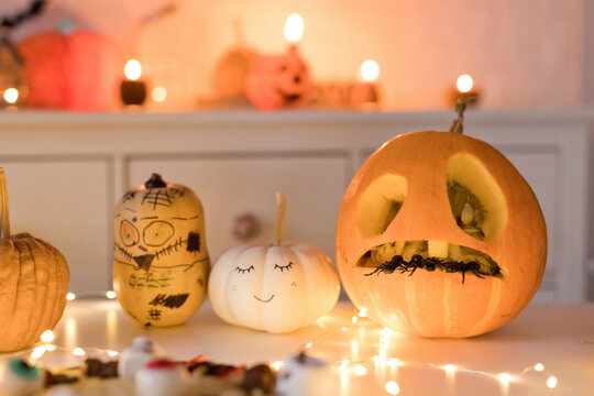 Pumpkin decorations near string light on table at home