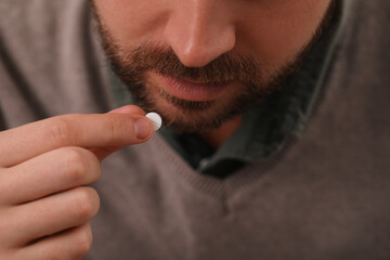 Closeup view of man taking antidepressant pill