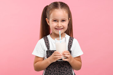 Cute girl with glass of fresh milk on pink background