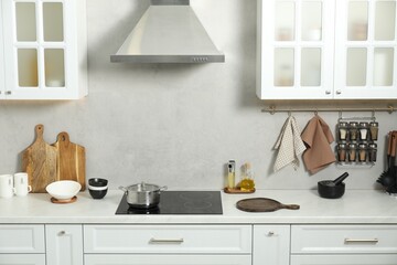 Wooden cutting boards and other cooking utensils on white countertop in kitchen