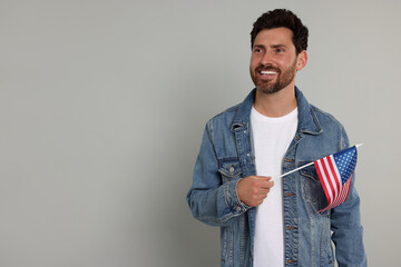 4th of July - Independence Day of USA. Happy man with American flag on grey background, space for...