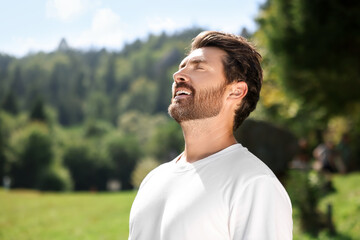 Feeling freedom. Man enjoying nature outdoors on sunny day, space for text