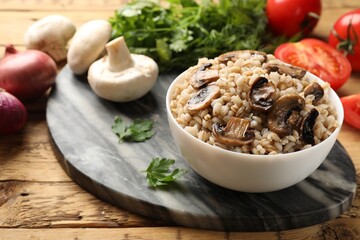 Delicious pearl barley in bowl served on wooden table