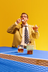Ping pong. Businessman in stylish suit drinking whiskey and snacking tennis ball against bright...