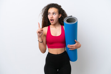 Young sport Arab woman going to yoga classes while holding a mat isolated on white background thinking an idea pointing the finger up