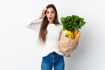 Young caucasian woman buying some food isolated on white background with surprise expression