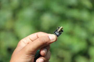 Laser diode used in making electronics prototyping projects held in the hand on nature background