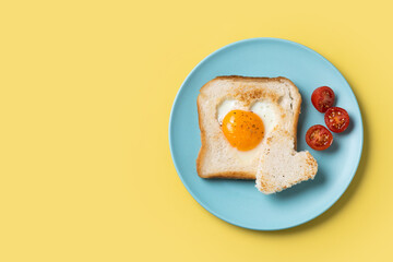 Valentine's Day breakfast with egg with tomatoes, heart shaped and toast bread on yellow background. Top view. Copy space - Powered by Adobe