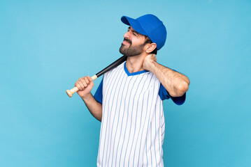 Young man playing baseball over isolated blue background with neckache