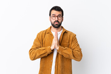 Caucasian handsome man with beard wearing a corduroy jacket over isolated white background keeps...