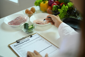 Cropped shot of dietitian in lab coat prescribing healthy diet or creating meal plan for patient at...