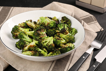 Tasty fried broccoli served on dark table, closeup