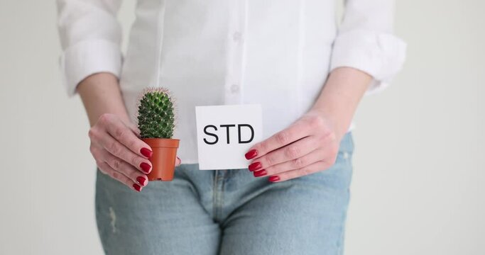 The girl holds a cactus and a sheet of paper, it is written by STD. The consequences of sexually transmitted diseases