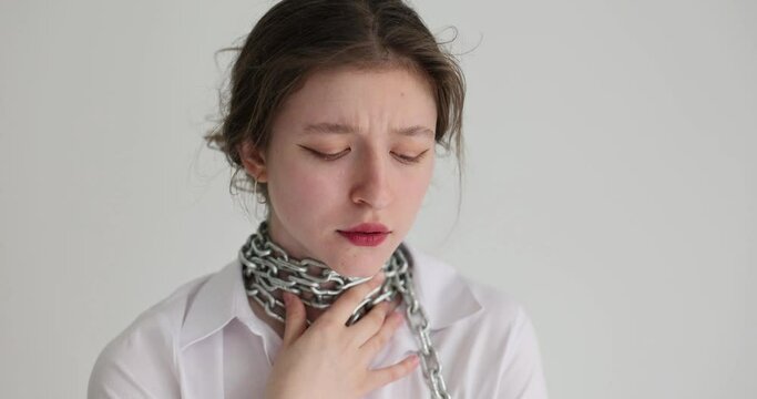 On the neck of a young woman is a steel chain, close-up. Concept for the coercion of women, violence