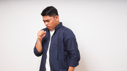 Young Asian man make coughing gesture on white background. studio shot