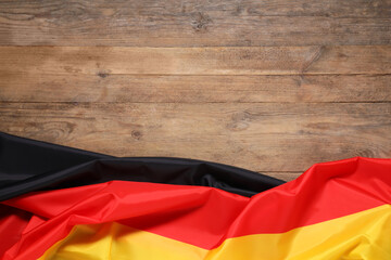 Flag of Germany on wooden background, top view. Space for text