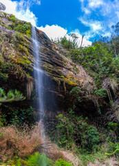Obraz premium Waterfall Long Exposure with Blue Sky and Verdant Forest