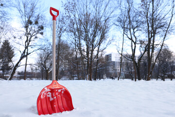 Snow shovel with wooden handle outdoors. Space for text