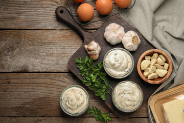 Tasty sauce with garlic and ingredients on wooden table, flat lay. Space for text