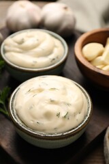 Tasty sauce with garlic on wooden table, closeup