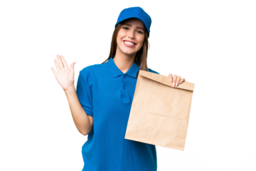 Young beautiful caucasian woman taking a bag of takeaway food over isolated background saluting with hand with happy expression