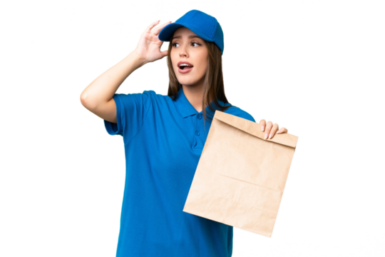 Young beautiful caucasian woman taking a bag of takeaway food over isolated background doing surprise gesture while looking to the side