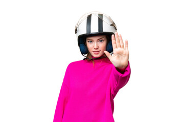 Young pretty woman with a motorcycle helmet over isolated chroma key background making stop gesture
