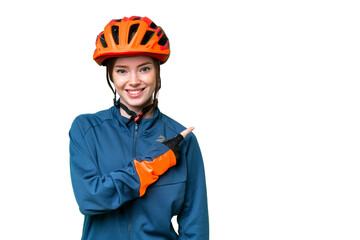 Young cyclist woman over isolated chroma key background pointing to the side to present a product