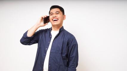 Asian young man showing happy face expression while talking on smartphone. studio shots against white background